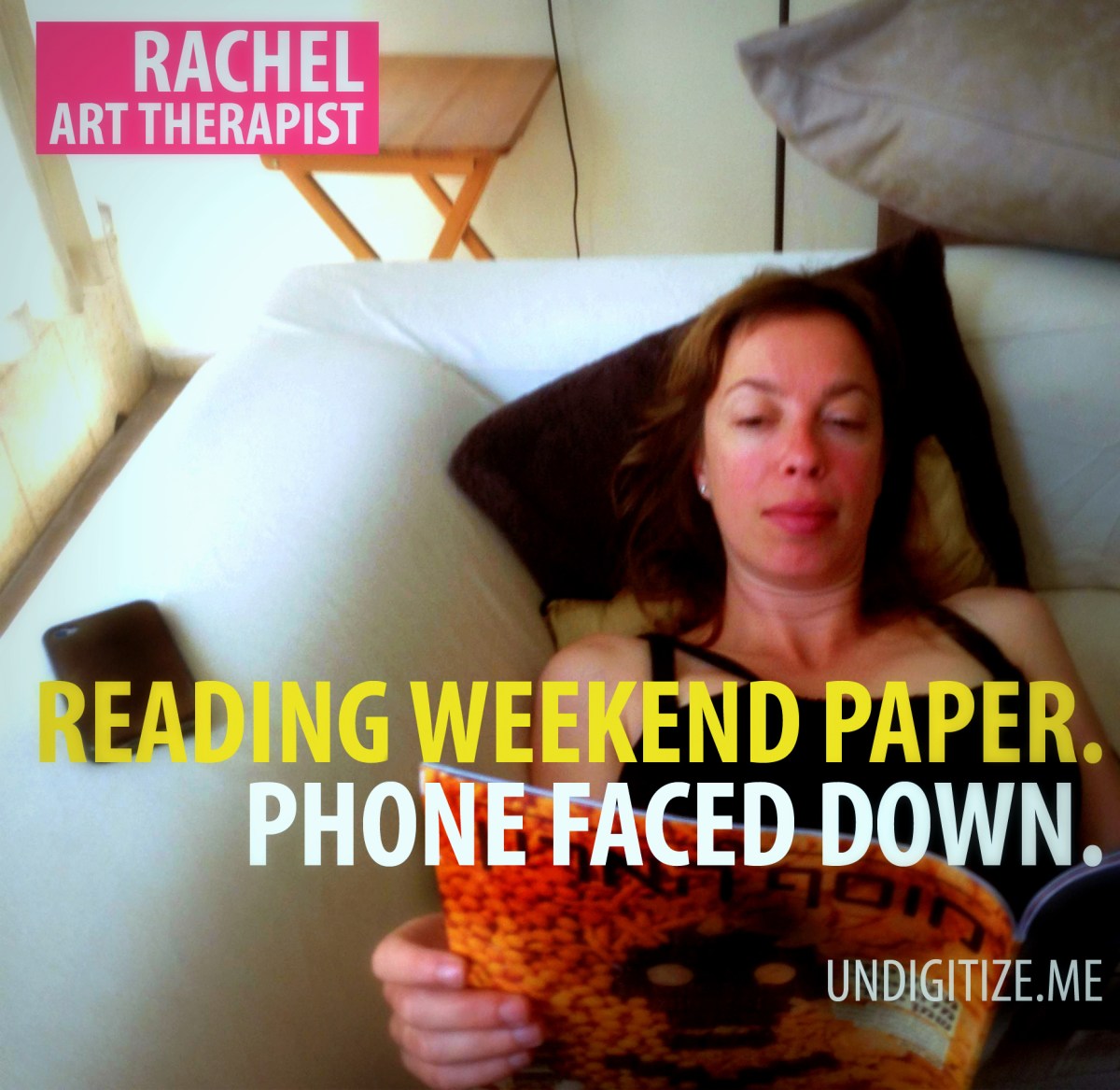 Reading Weekend Paper. Phone Faced Down.